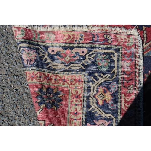 313 - North west Persian hand-knotted rug decorated with three floral and geometric octagonal medallions t... 