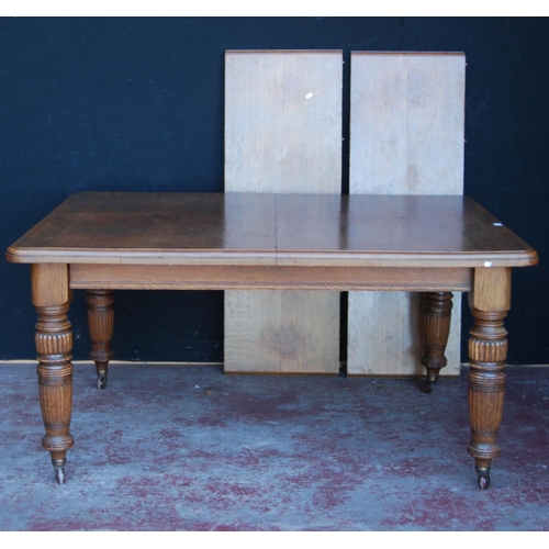 364 - Edwardian oak extending dining table with two additional leaves, on carved baluster supports and cas... 