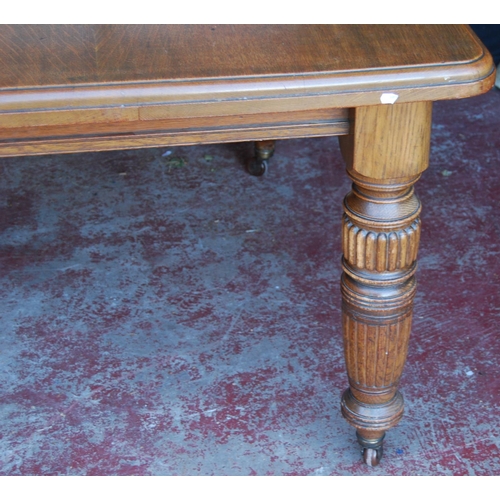 364 - Edwardian oak extending dining table with two additional leaves, on carved baluster supports and cas... 