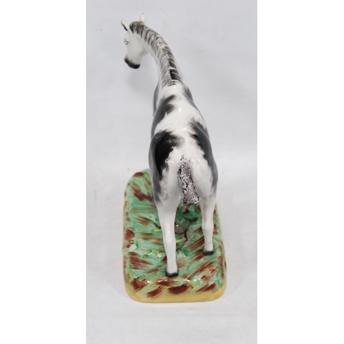 222 - Late 19th century Staffordshire figure of a black and white horse, fixed to a painted base, 24cm hig... 