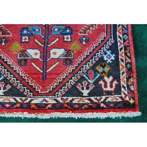 302 - Qashqai hand-knotted runner decorated with four geometric medallions on red ground, 230cm x 136cm.