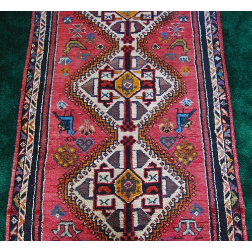 302 - Qashqai hand-knotted runner decorated with four geometric medallions on red ground, 230cm x 136cm.