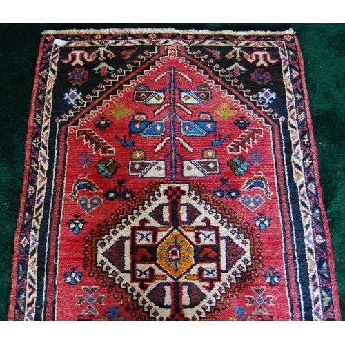 302 - Qashqai hand-knotted runner decorated with four geometric medallions on red ground, 230cm x 136cm.