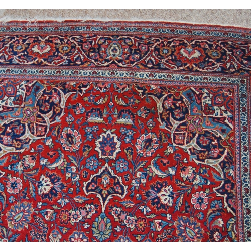 303 - Persian Kashan rug decorated with all over floral swags on a red ground, 224cm x 136.5cm.