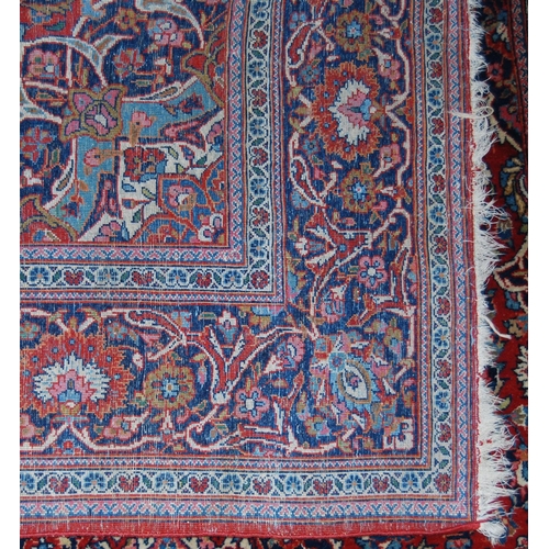 303 - Persian Kashan rug decorated with all over floral swags on a red ground, 224cm x 136.5cm.