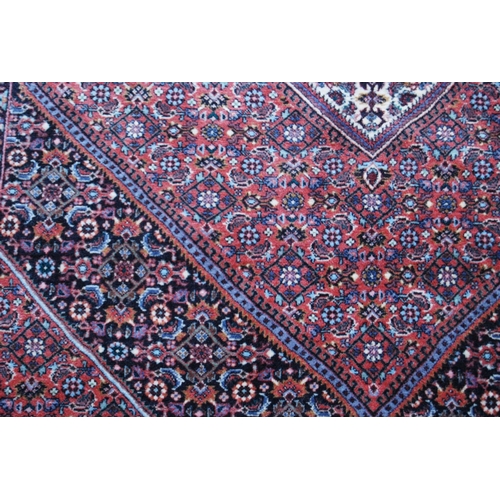 304 - Bidjar rug decorated with graduated geometric centre on a cream and red ground, 178cm x 113cm.