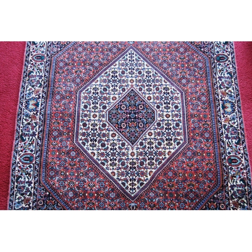 304 - Bidjar rug decorated with graduated geometric centre on a cream and red ground, 178cm x 113cm.