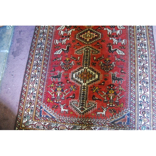 306 - Persian rug decorated with all over geometric medallions and motifs on a red ground with cream borde... 