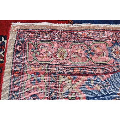 308 - Dosemealti hand-knotted rug decorated with a large geometric medallion to the centre, on a red groun... 