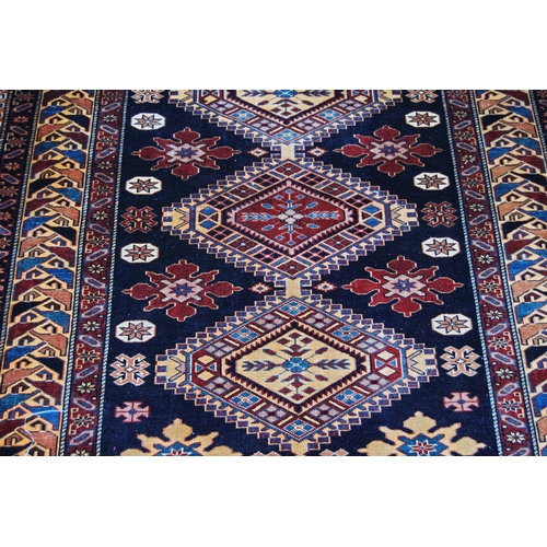 310 - Qashqai rug decorated with five geometric medallions on a blue ground with a red and cream border, 1... 