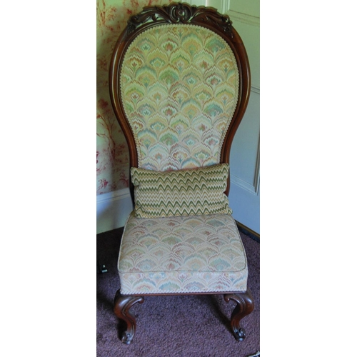 335 - Victorian mahogany spoon-back nursing chair upholstered in later floral fabric, on scroll supports, ... 