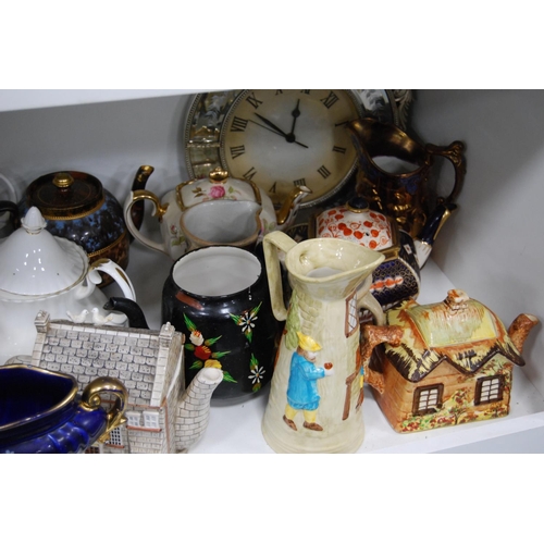 194 - Ceramic and pottery teapots, water pots, lustre jug, modern wall clock, glassware etc (one shelf).