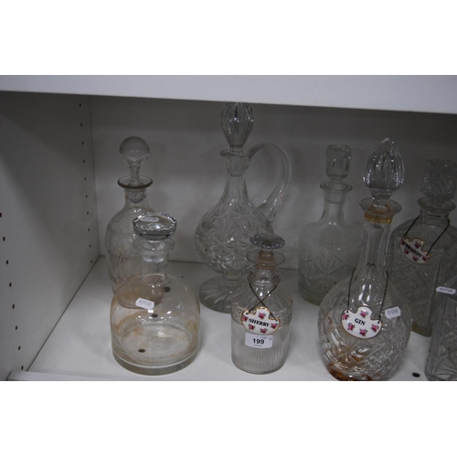 199 - Eight crystal and cut glass decanters, some with ceramic spirit labels (one shelf).