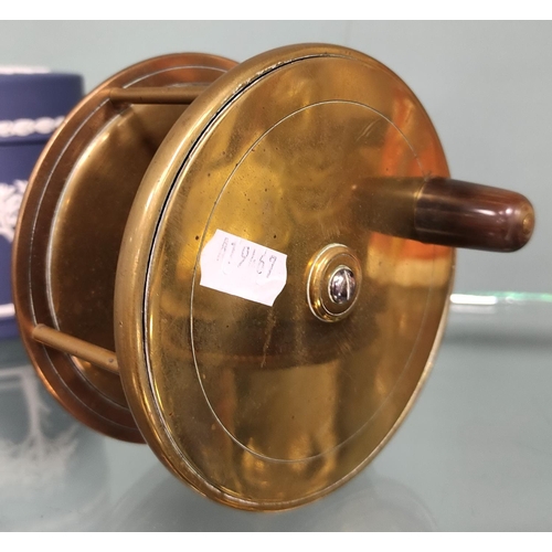 267 - Brass fishing reel and a brass-mounted leather tape measure.  (2)