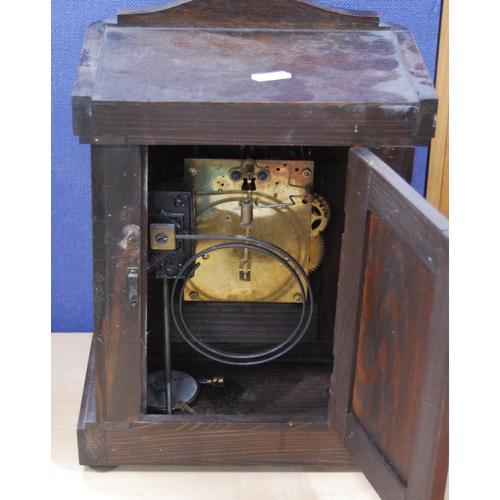 52 - Oak-cased mantel clock with silvered dial and twin train movement.