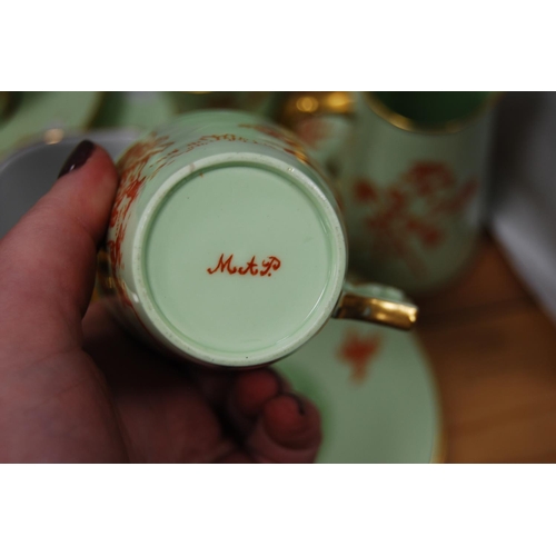 84 - Green and gilt glazed part tea/coffee set, signed 'MAP' to the underside to include teapot (15) and ... 