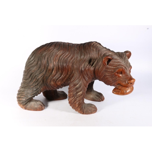 116 - Black Forest style carved wood model of a bear with fish, 50cm long.