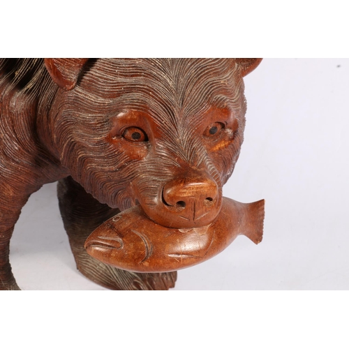 116 - Black Forest style carved wood model of a bear with fish, 50cm long.