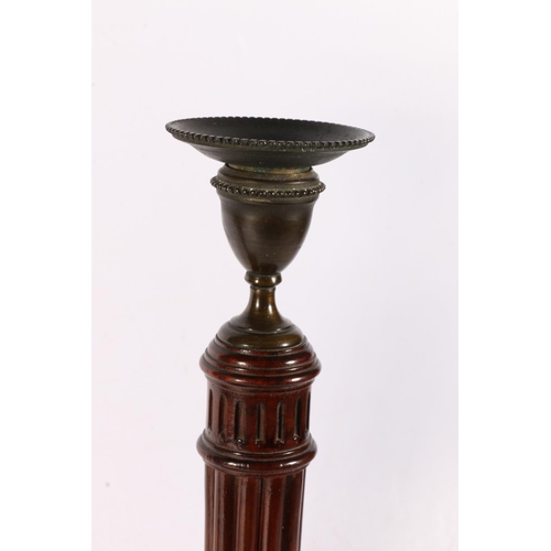 133 - Pair of carved mahogany and metal candlesticks raised on reeded and fluted stems, 35cm tall. 