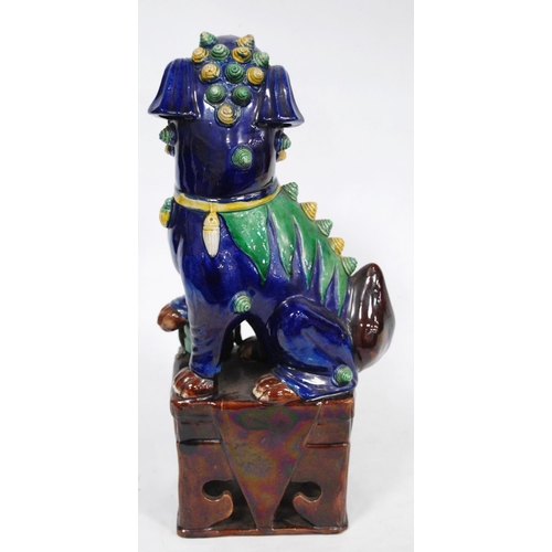 251 - Chinese pottery temple guardian (Dog of Fo), glazed in brown, yellow and green on a blue ground, fix... 