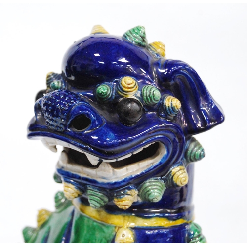 251 - Chinese pottery temple guardian (Dog of Fo), glazed in brown, yellow and green on a blue ground, fix... 