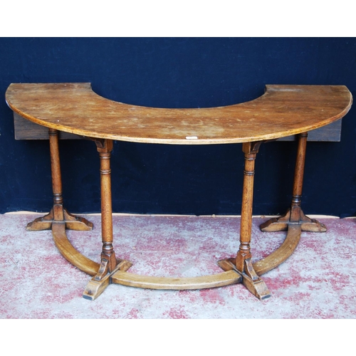 385 - Oak reading/library table of curved form with extending drop flaps, on turned supports, label to the... 