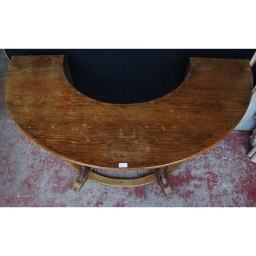 385 - Oak reading/library table of curved form with extending drop flaps, on turned supports, label to the... 