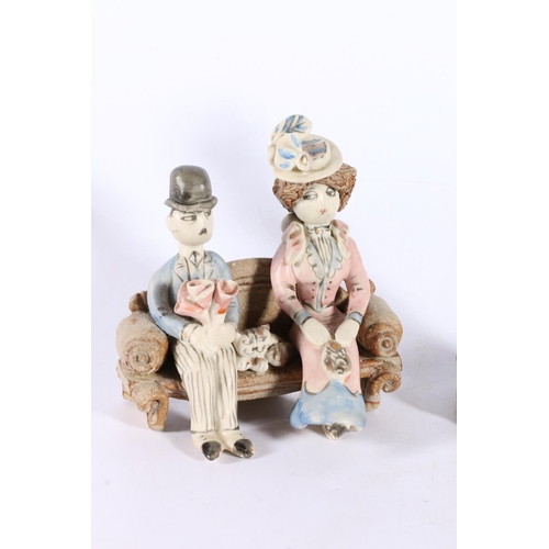 13 - Laura Dunn Studio Pottery figure groups of a husband and wife with cat, 13cm and 10cm tall.  (2)