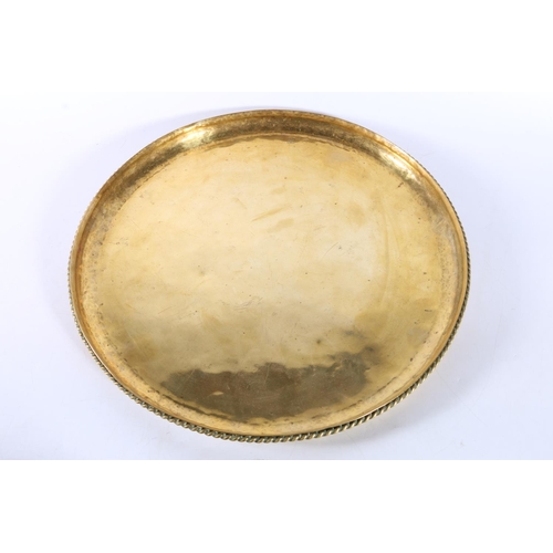 31 - Hugh Wallis of Altrincham, an Arts and Crafts brass charger dish with rope twist border, HW monogram... 