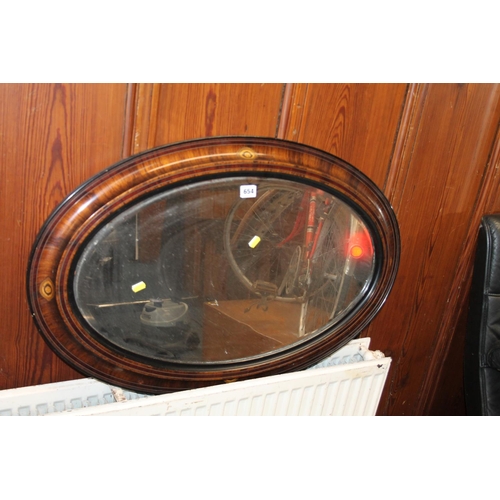 654 - Bevel edged mahogany and ebonised framed wall mirror, 83cm x 52cm.