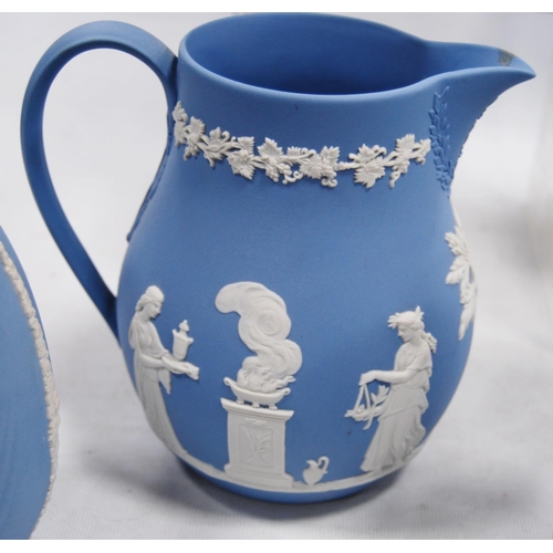 234 - Six pieces of Wedgwood blue Jasper ware comprising two jugs, two spill vases and a small planter, al... 