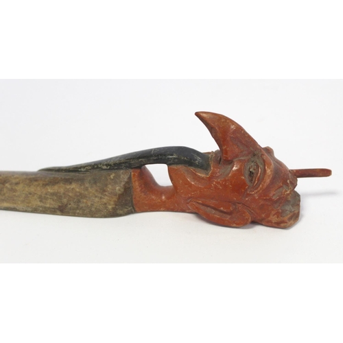 215 - Late 19th century Indian carved and stained wooden page turner, the handle in the form of a demon wi... 