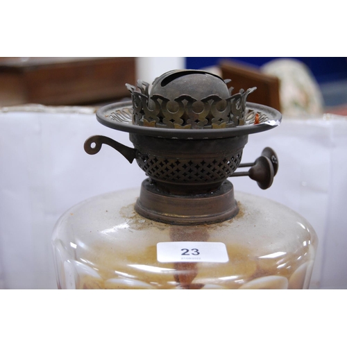 23 - Brass-mounted oil lamp with amber-coloured glass reservoir.