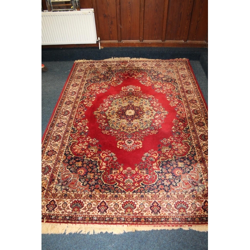 445 - Red ground Eastern style floral fringed rug, 240 x 171cm.