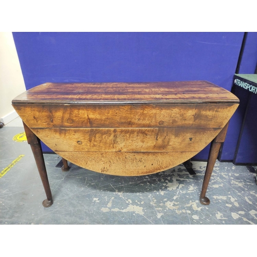 465 - 18th century oval oak drop leaf dining table on turned tapered supports with pad feet. W.118cm.