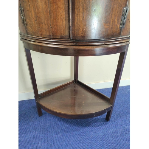 493 - Georgian oak bow front corner cupboard with twin doors enclosing shelved interior, raised on wooden ... 