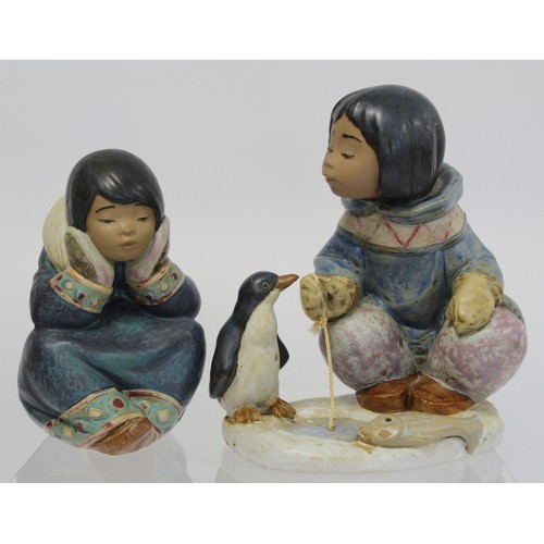 232B - Two Lladro Gres figures of Inuit children, one crouching beside an ice fishing hole with penguin, 20... 