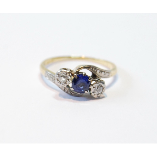 111 - Diamond and sapphire three-stone cross-over ring with diamond-set shoulders, in gold, '18ct', size P... 