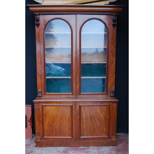 388 - Victorian mahogany library bookcase with two arched glazed doors enclosing a shelved interior, flank... 