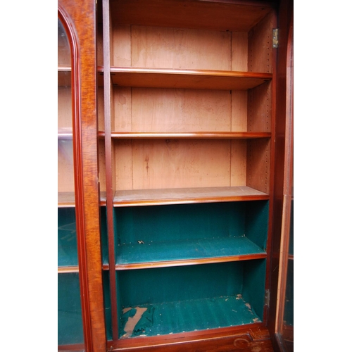 388 - Victorian mahogany library bookcase with two arched glazed doors enclosing a shelved interior, flank... 