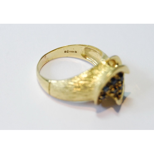 77 - 18ct gold ring with double spiral enclosing eleven sapphire collets, 1974, size M, 5g.