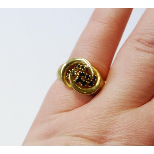 77 - 18ct gold ring with double spiral enclosing eleven sapphire collets, 1974, size M, 5g.