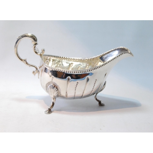 82 - Irish silver sauce boat of large size, crested, with waved flutes and punch bead border, on pad feet... 