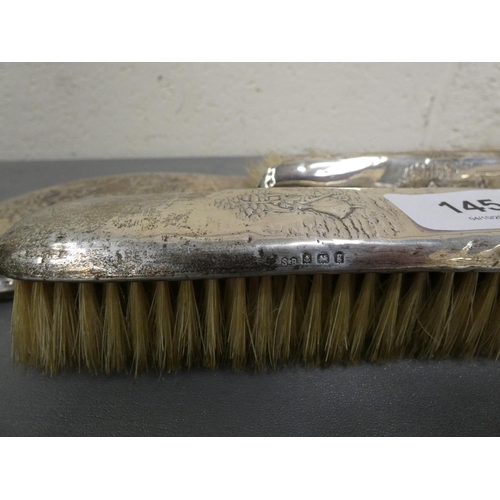 145 - Silver backed mirror and two brushes (a/f).