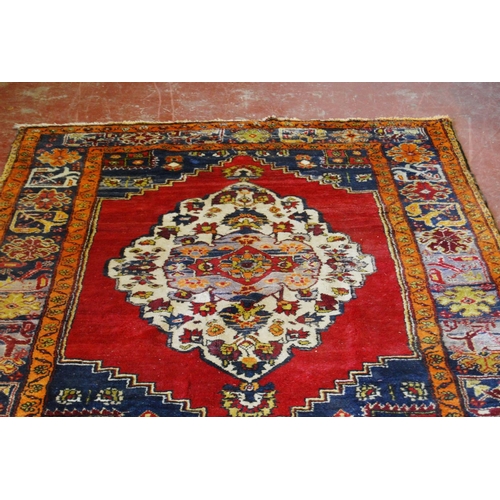 317 - Old Turkish Konya rug decorated with a central floral medallion and geometric and floral motifs to t... 