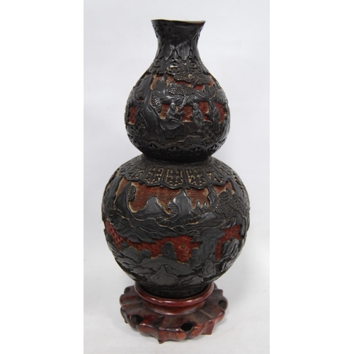 253 - Pair of 20th century Chinese black on red double gourd cinnabar vases decorated with figures, on red... 