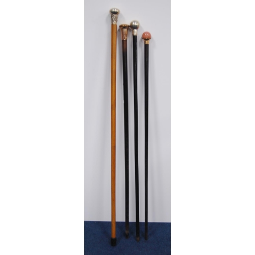 203 - Four walking sticks to include three ebonised sticks with silver, rose-coloured, quartz-style pommel... 