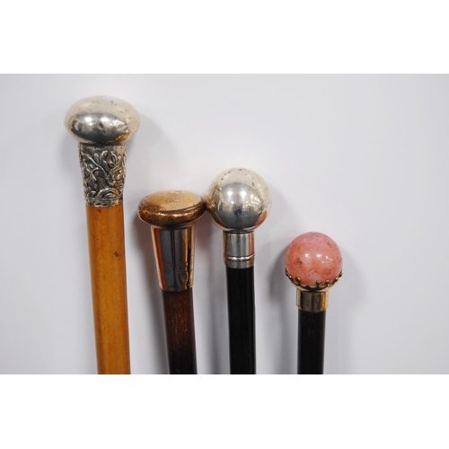 203 - Four walking sticks to include three ebonised sticks with silver, rose-coloured, quartz-style pommel... 