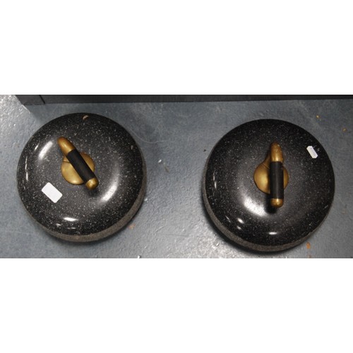 168 - Pair of curling stones, each with a brass and wood grip.  (2)