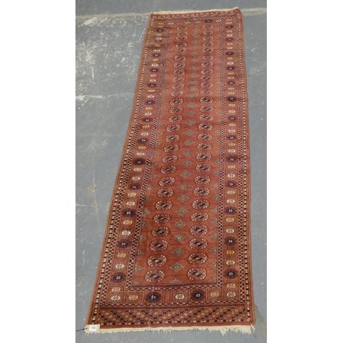 459 - Bokhara runner, with twenty six rows of two geometric motifs to the centre and border on red ground,... 